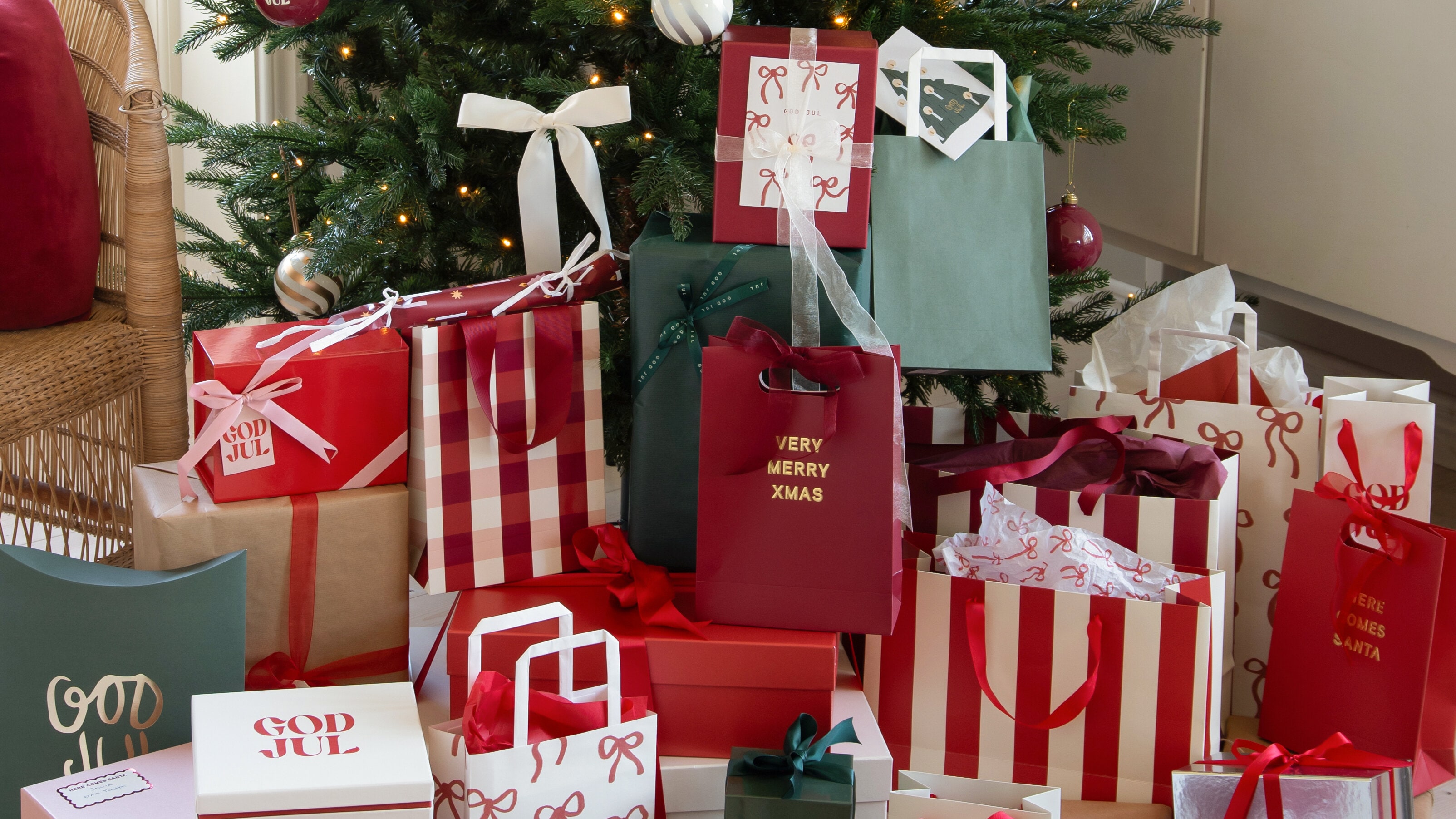 Inslagna julklappar framför en julgran