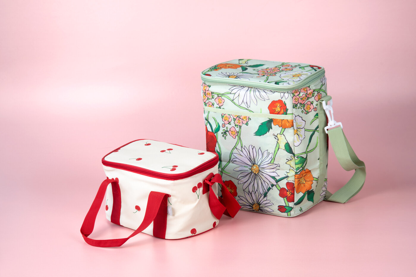 Cooler bags with summery pattern against pink background.