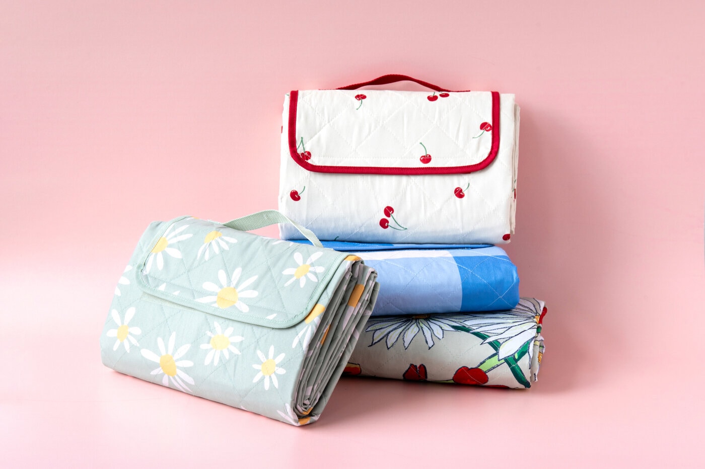 Picnic blankets with various patterns against a pink background.