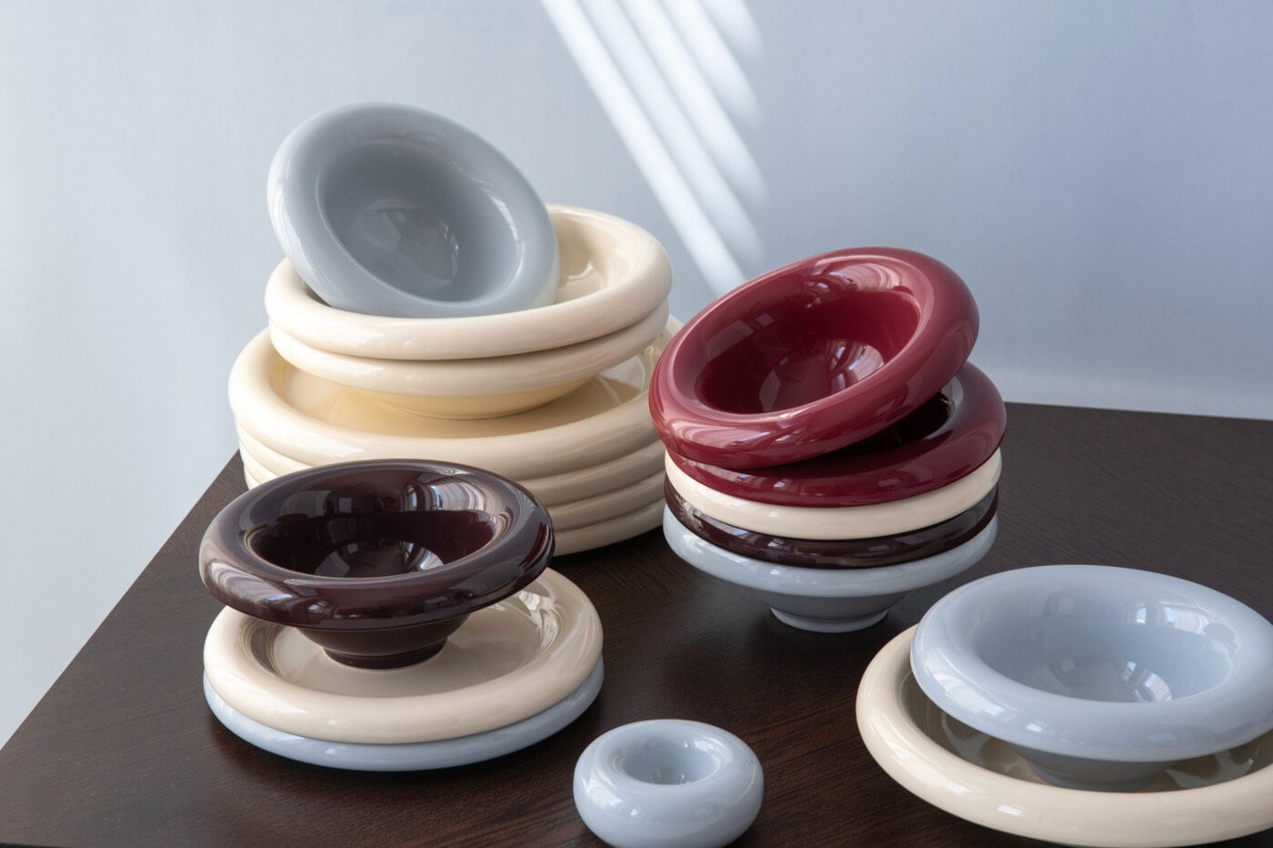 Bullig bowls in beige, burgundy and light blue standing on a table.