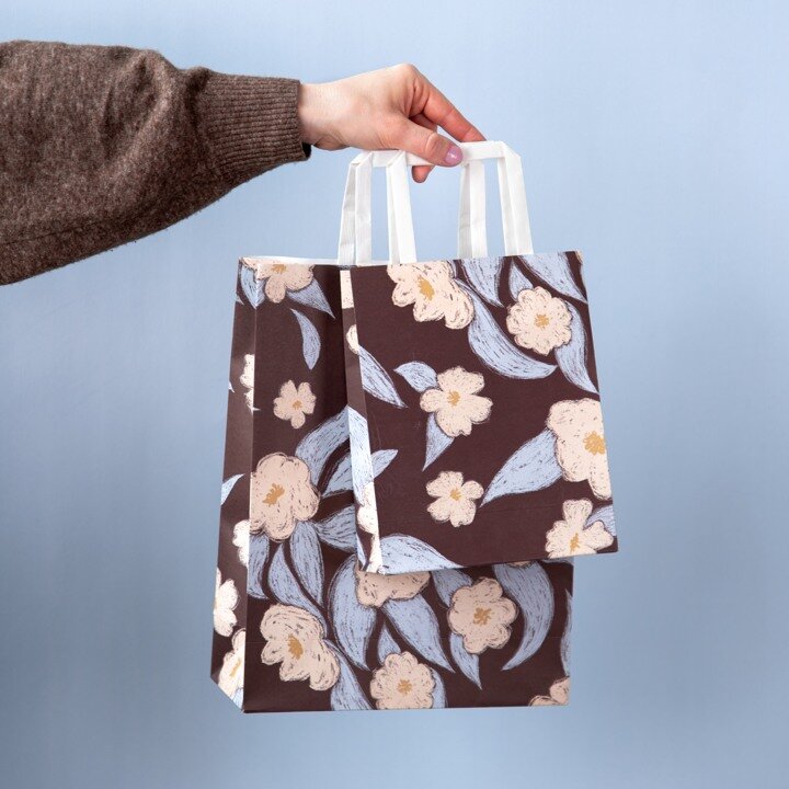 Person holding a floral gift bag as inspiration for gifts and gift wrapping.