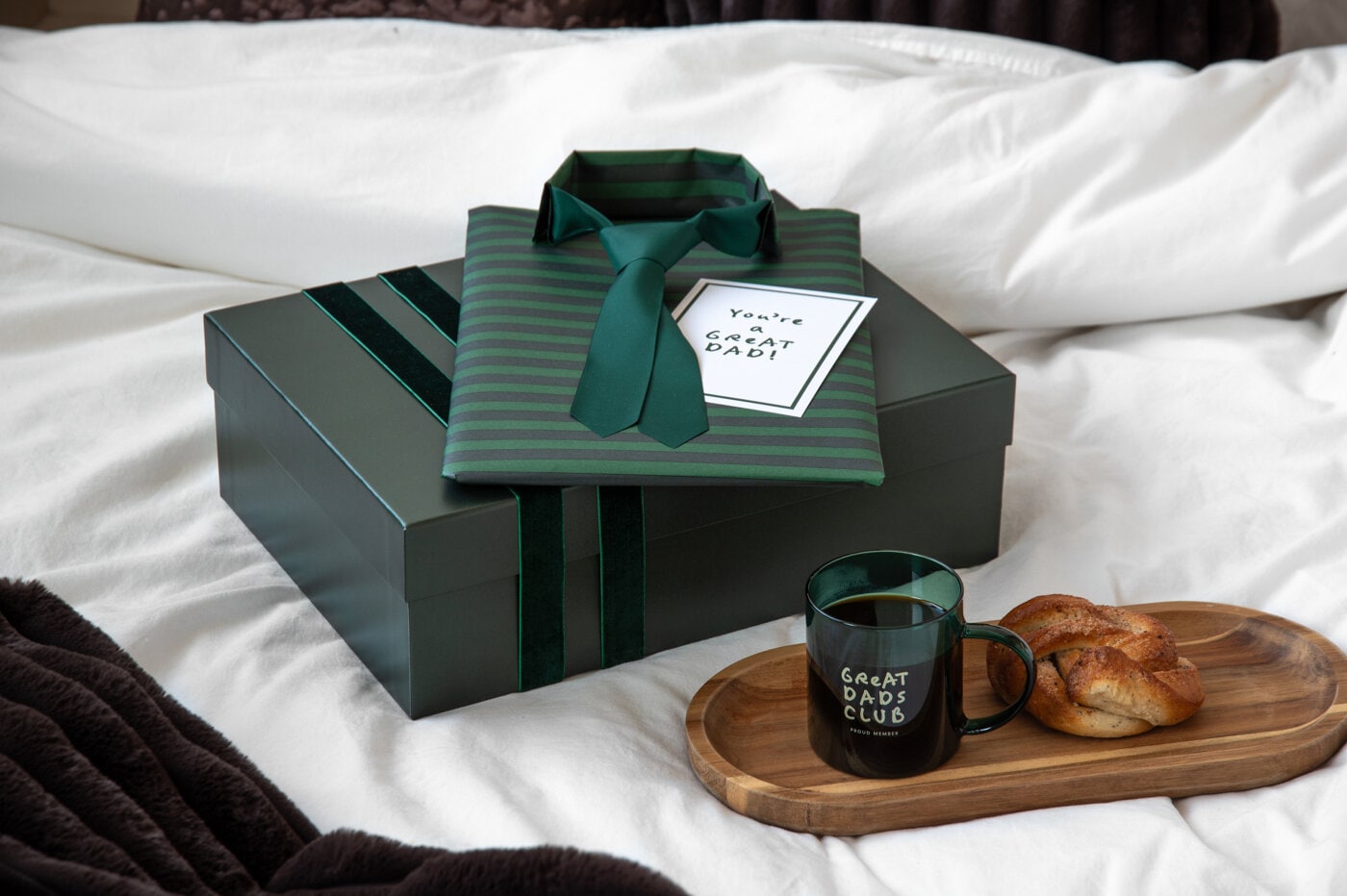 Father’s Day gifts in green, featuring a gift box, shirt and tie, coffee mug, and bun.