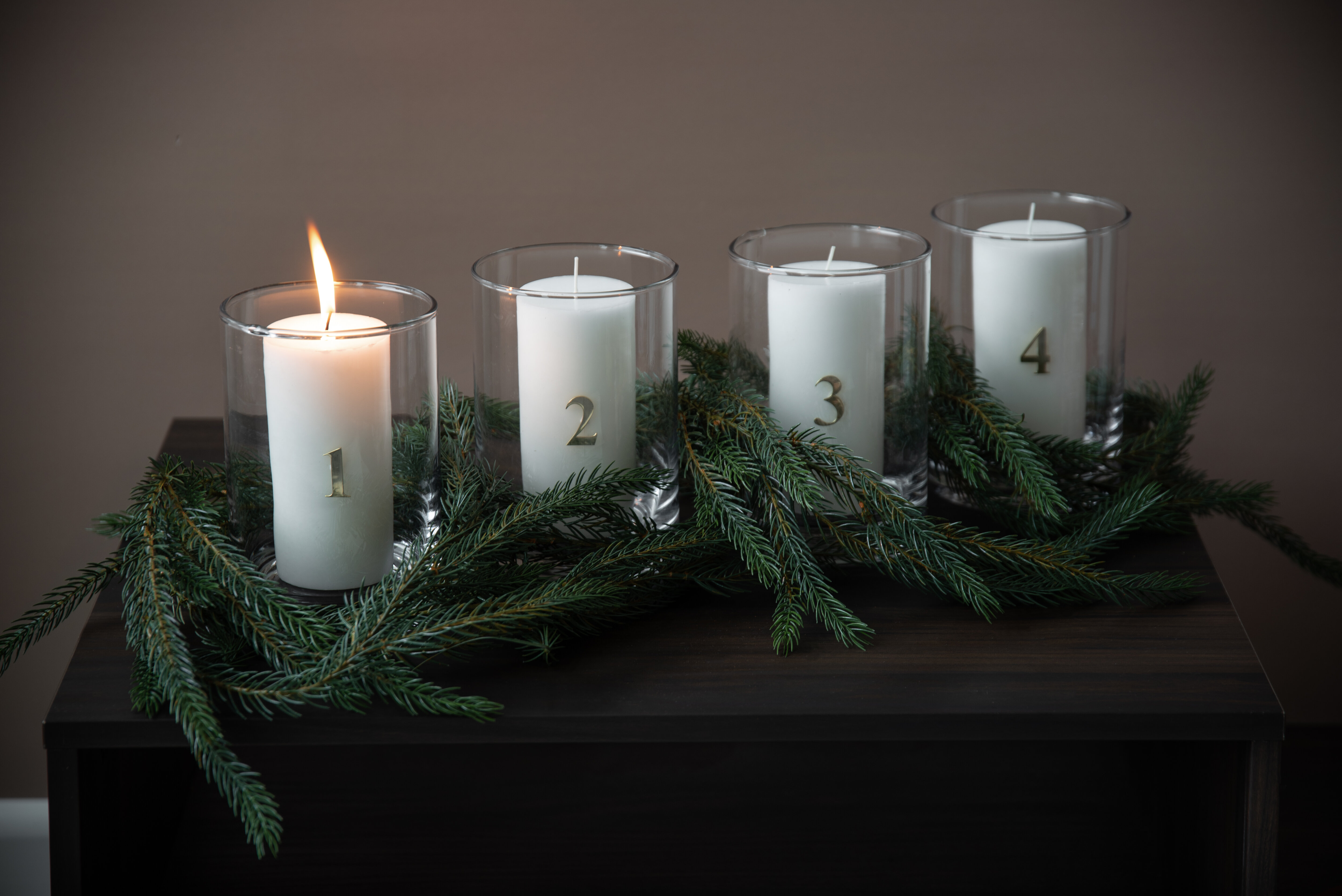 White candles tied together with string, placed on artificial snow.