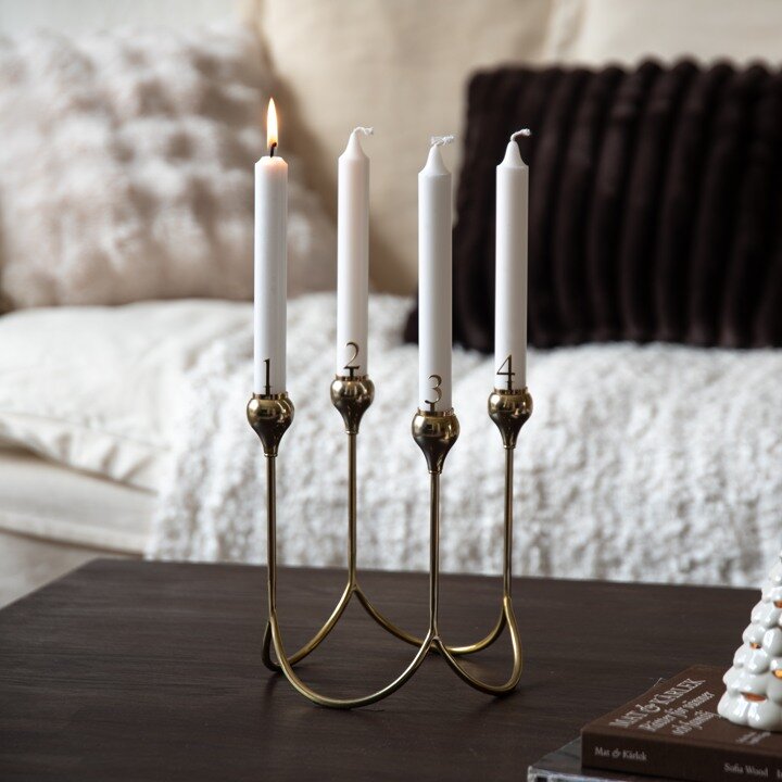 Gold-coloured candelabra with lit white taper candles.