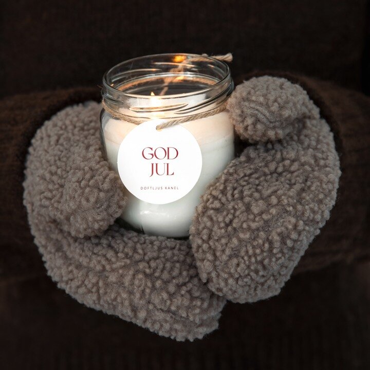 Lit scented candle with a God Jul label.