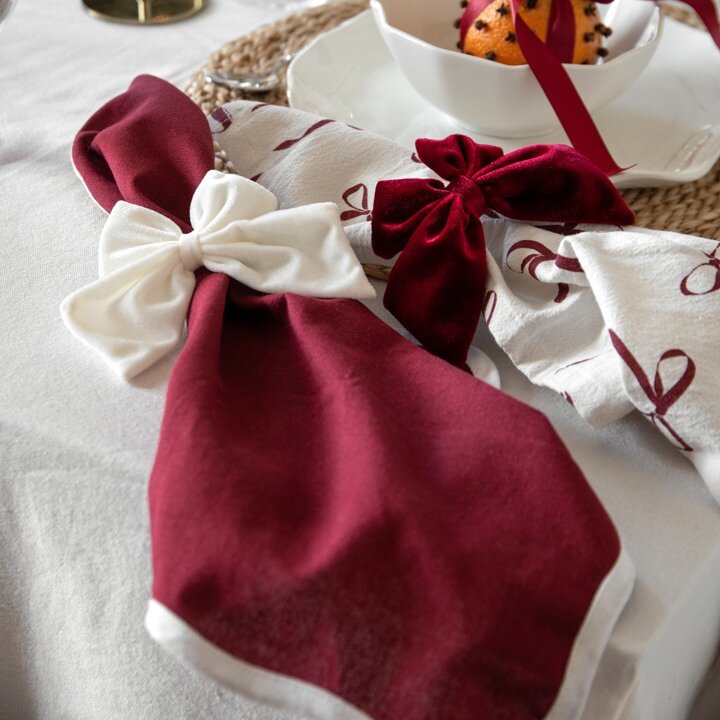 Burgundy and white taper candles with stripes and bow patterns.