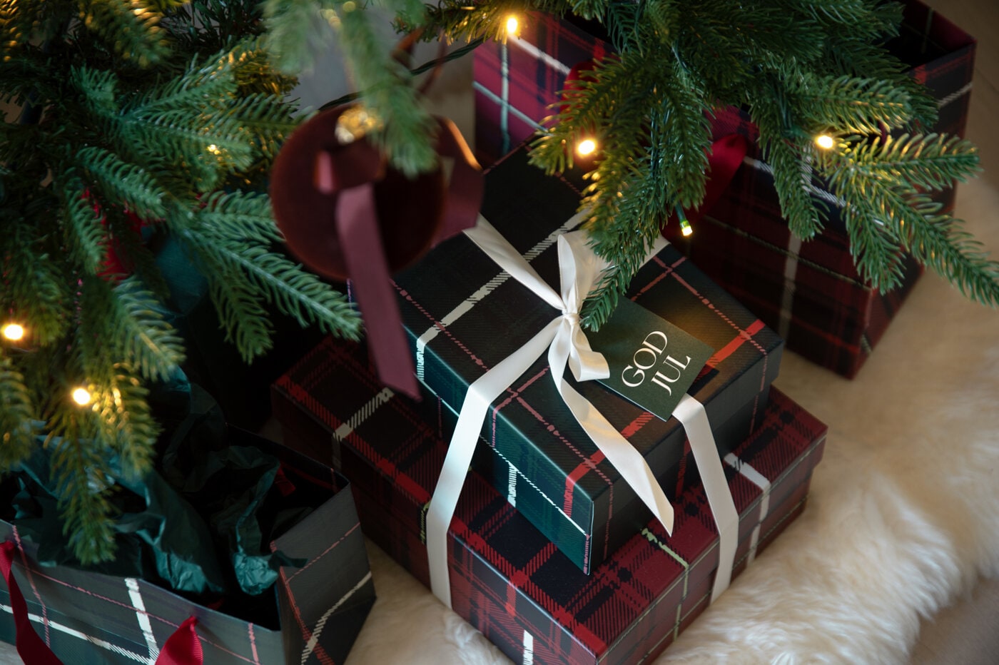 Christmas gifts wrapped in green, white and striped gift paper with red ribbons and gift tags