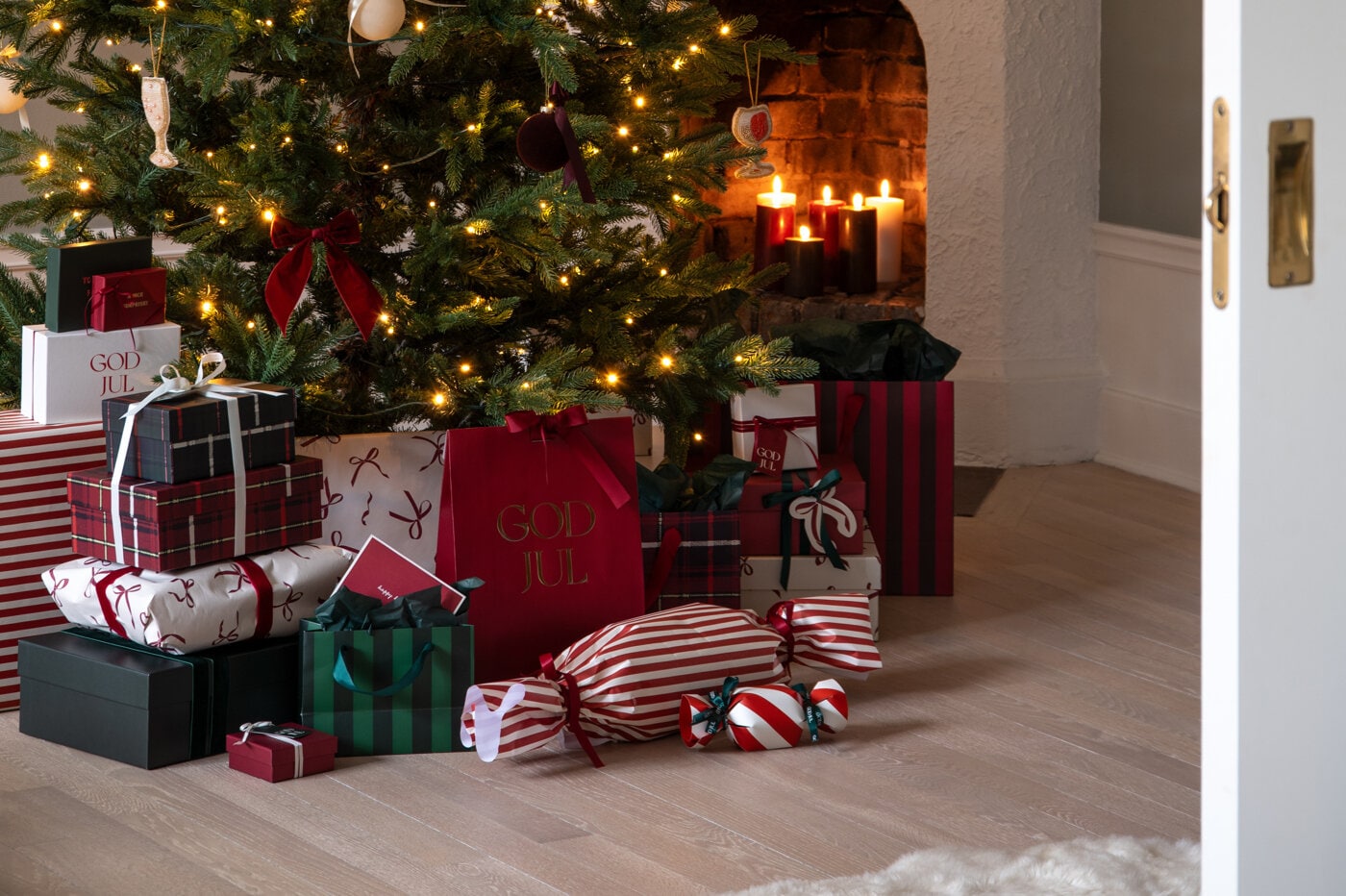 Christmas gifts wrapped in tartan paper with white ribbons under a decorated Christmas tree.