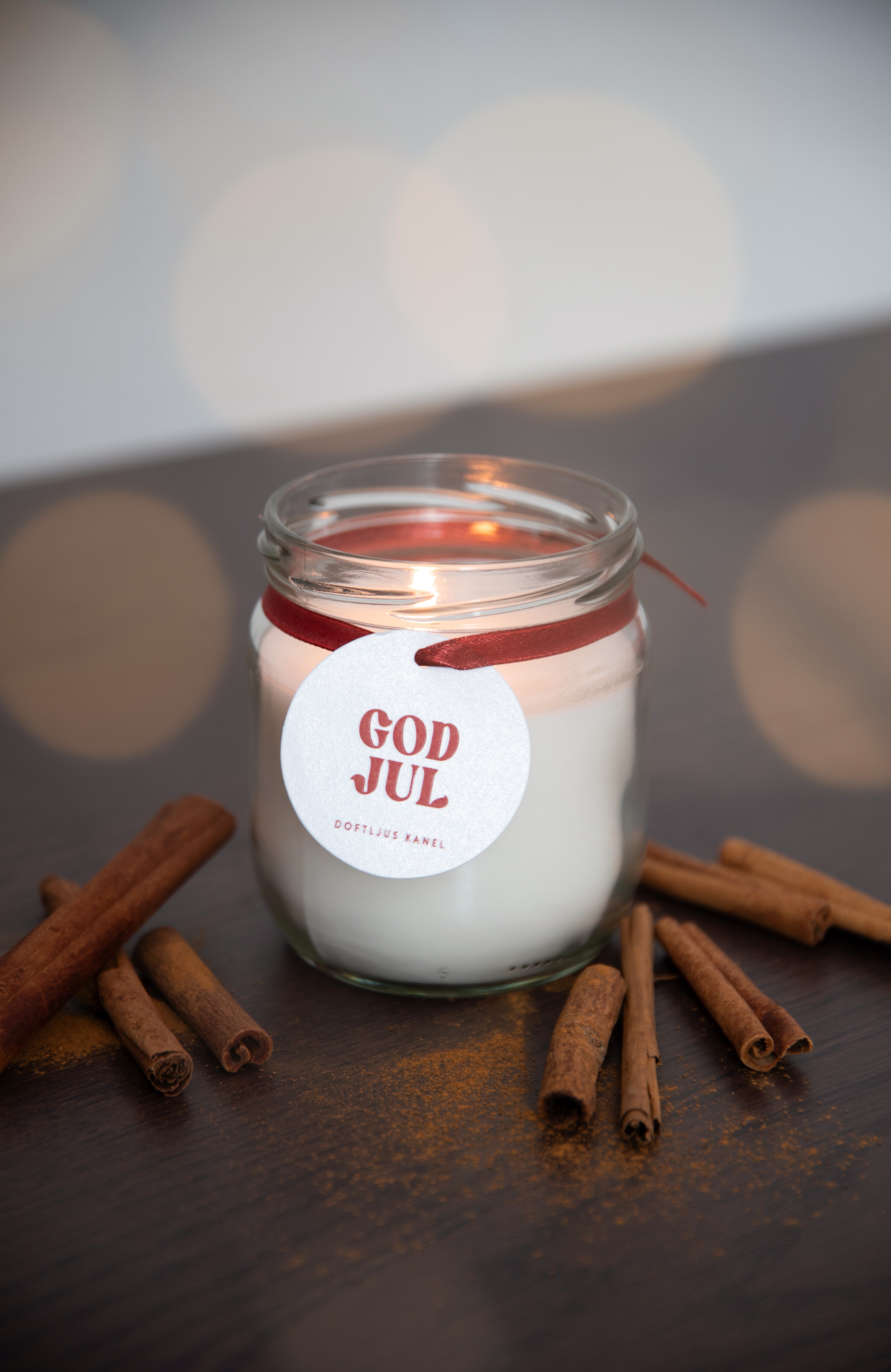 Christmas scented candle in a glass jar with cinnamon sticks.