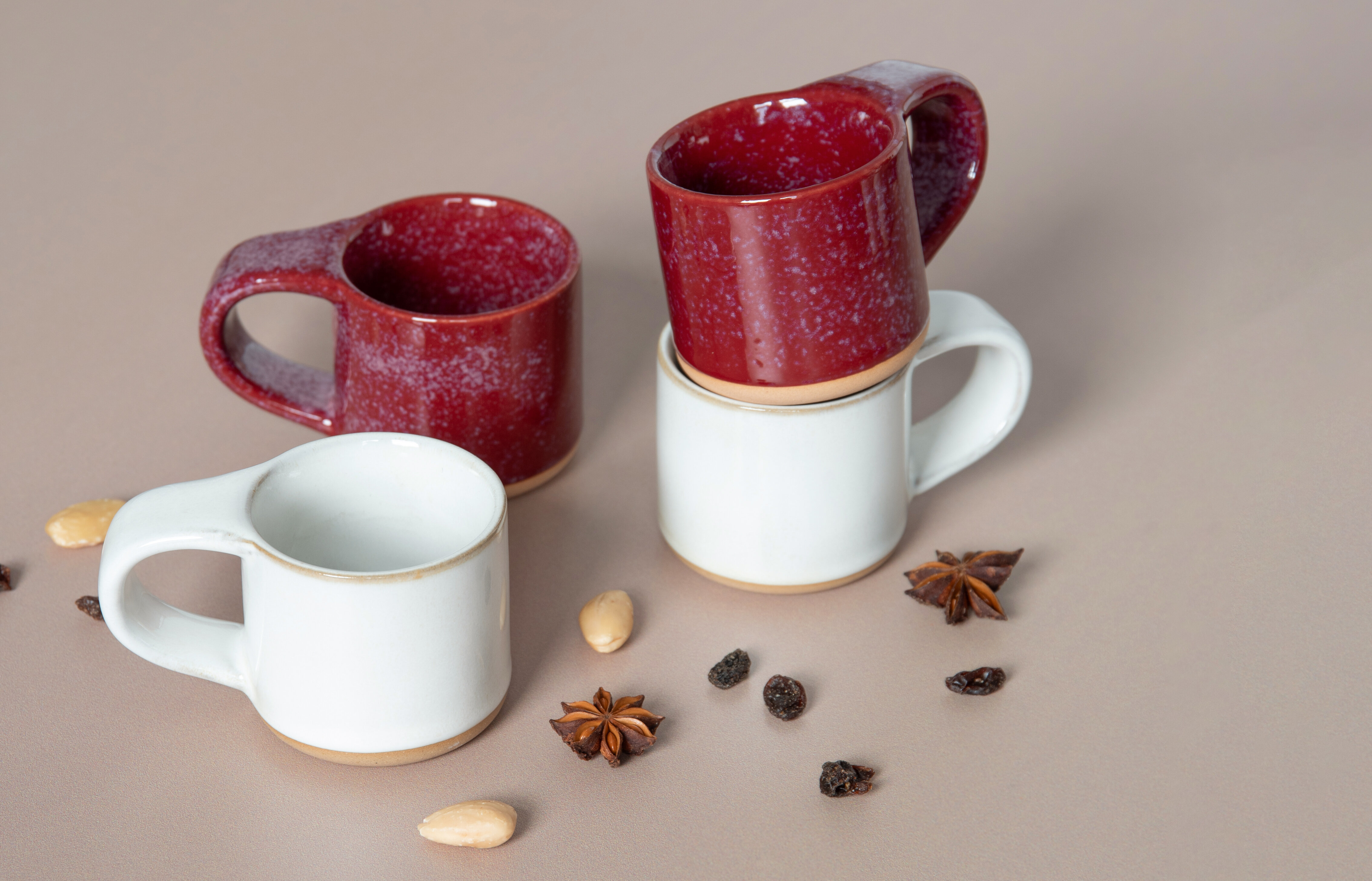 Several taper candles in different colors – red, green, white, and brown – placed on green tissue paper.