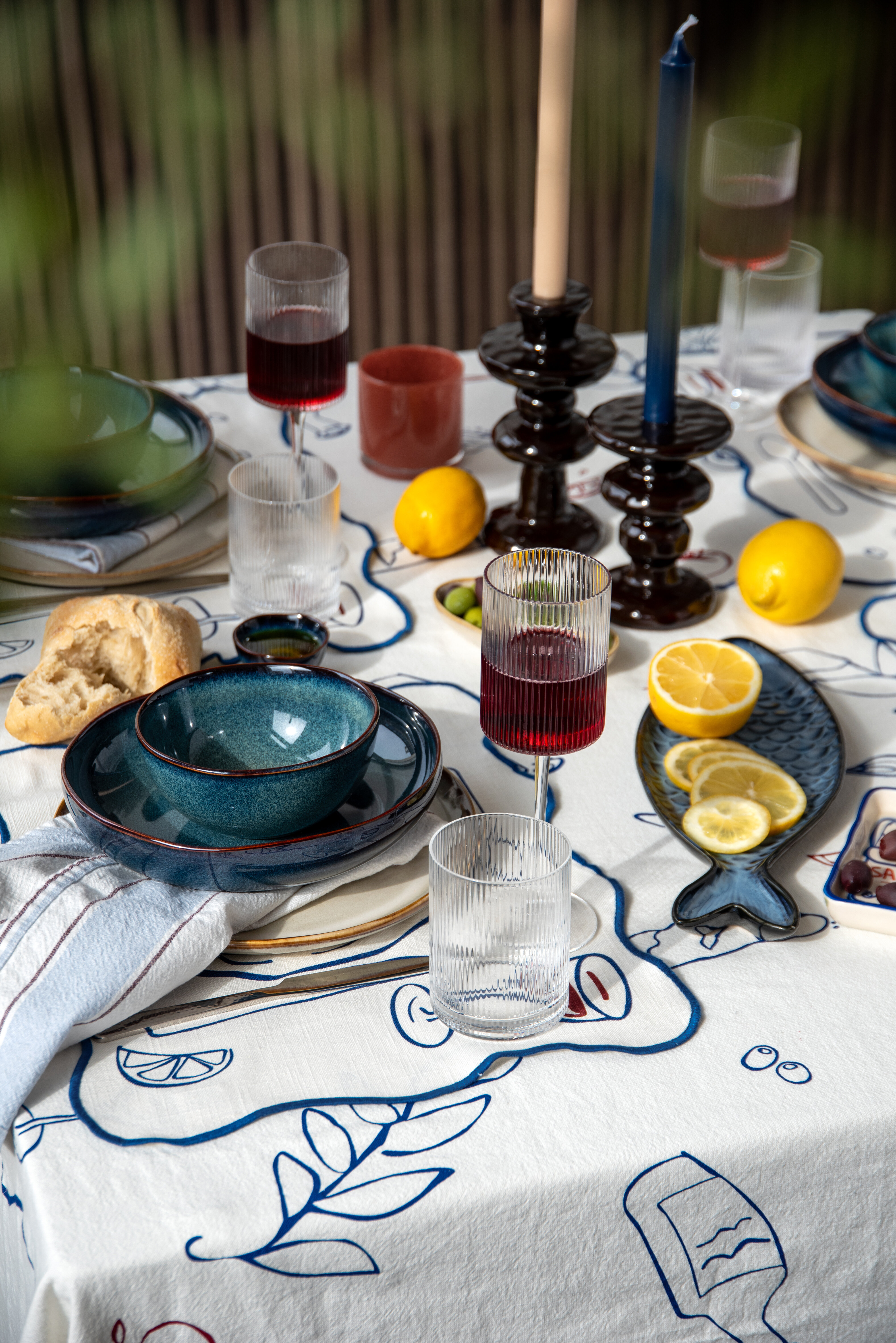 Set dining table with blue tableware and lemons.