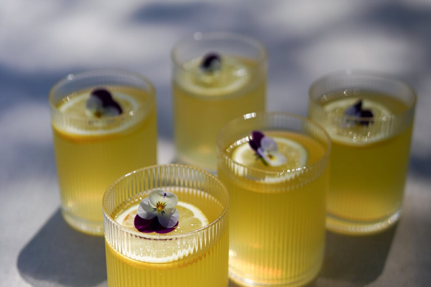 Glasses with yellow drink.