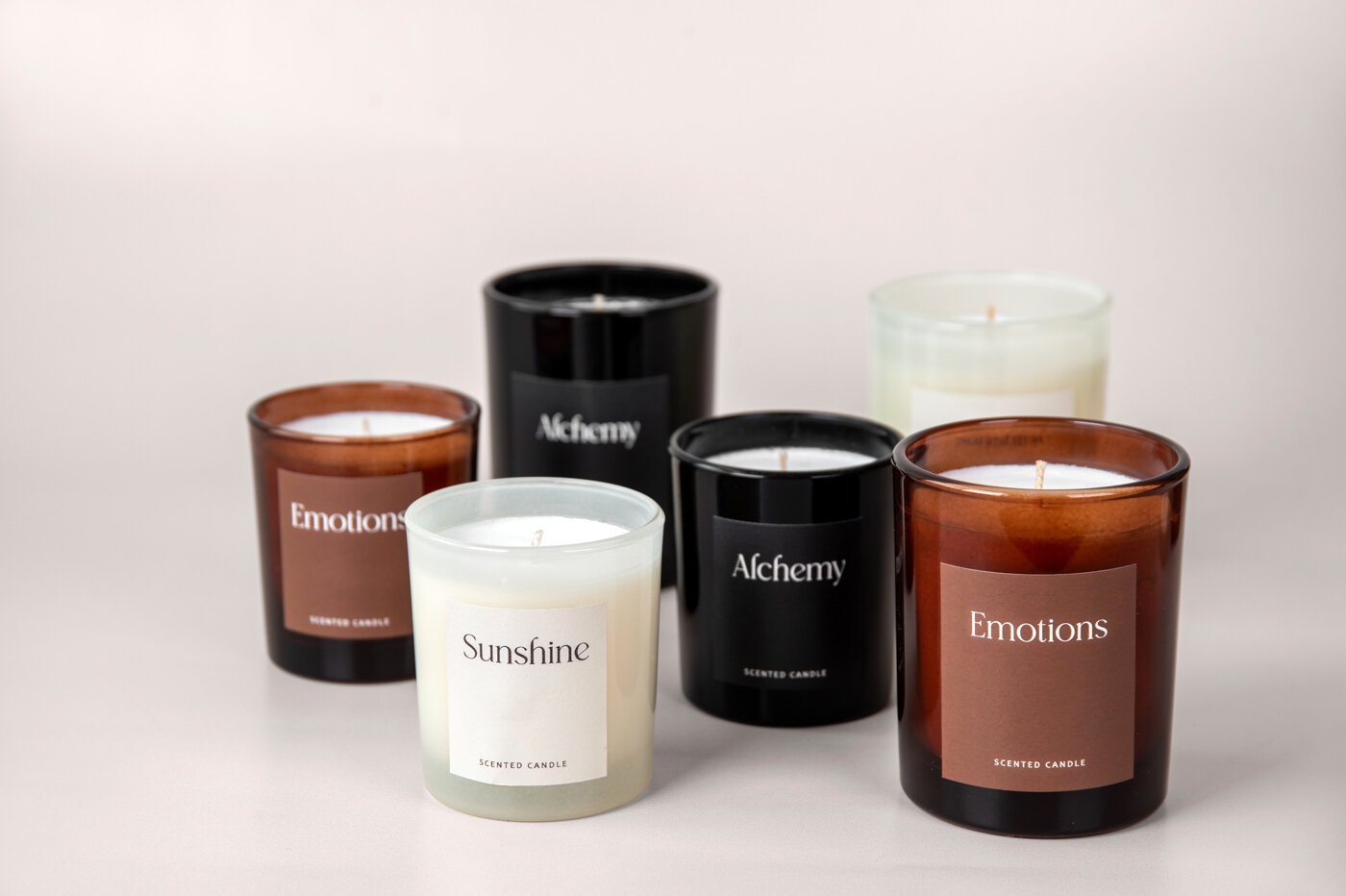 Scented candles in brown, black and white glass jars.