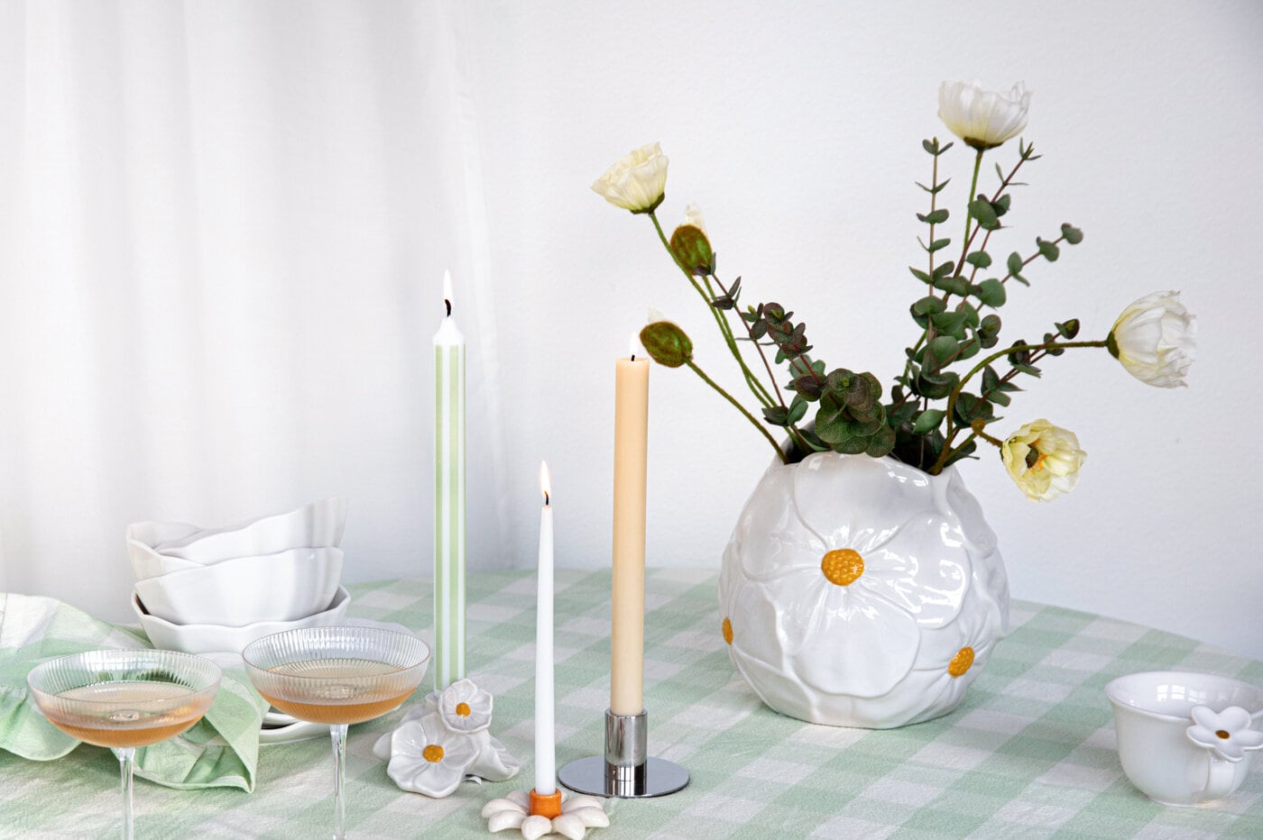 White vase with flowers on a spring-set table