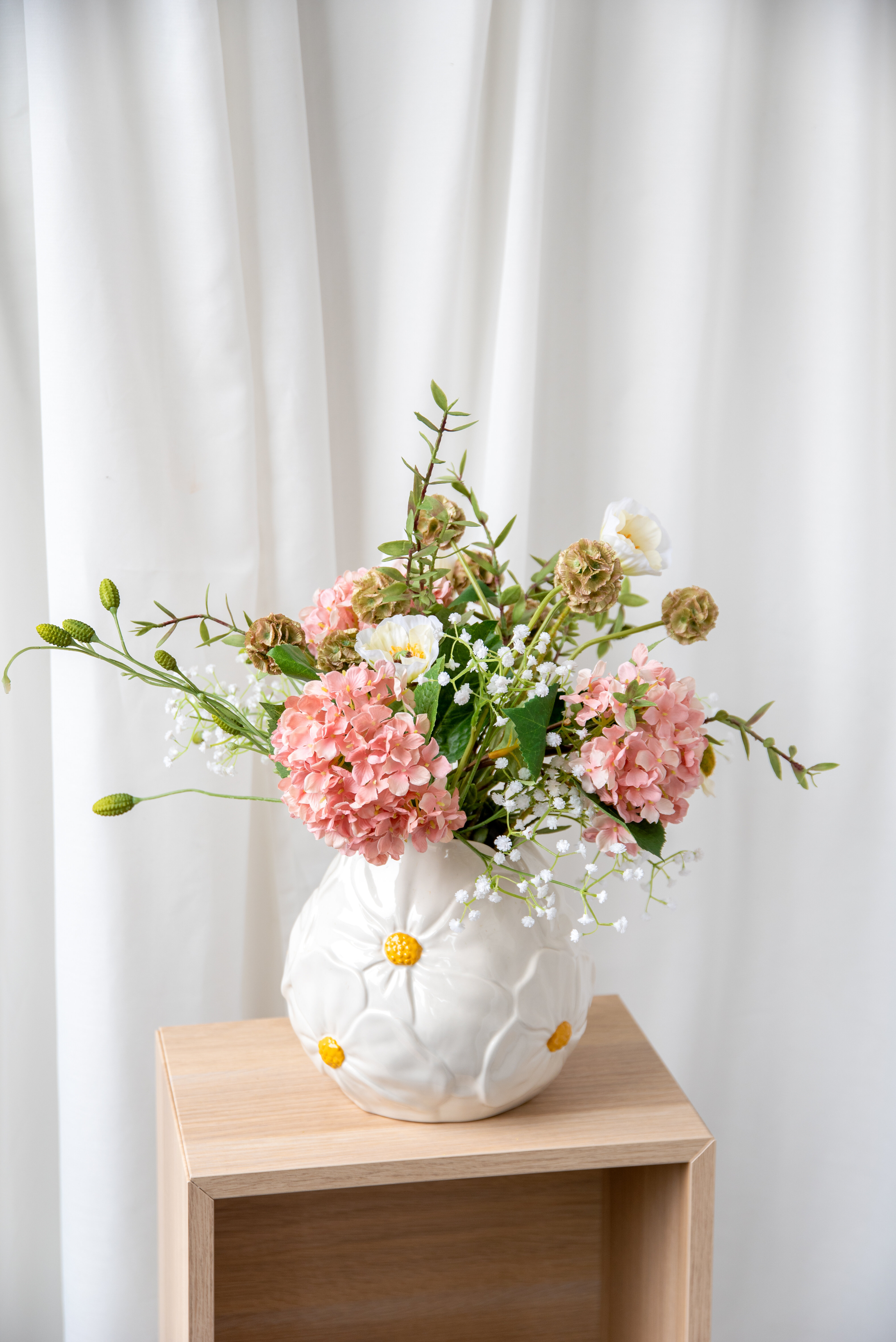 Bouquet of pink flowers in a white vase.