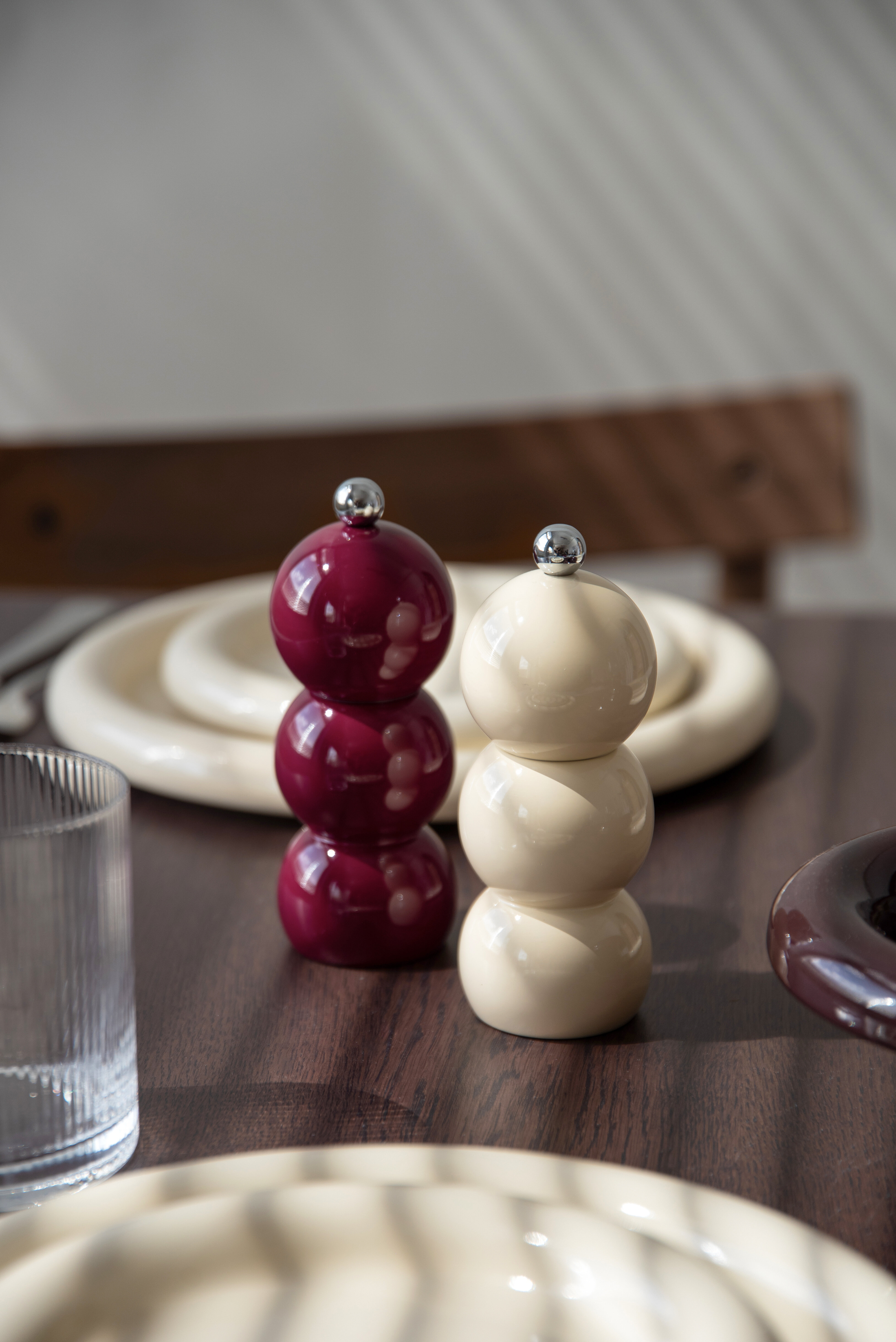 Burgundy and white sculptural salt and pepper shakers on a table.