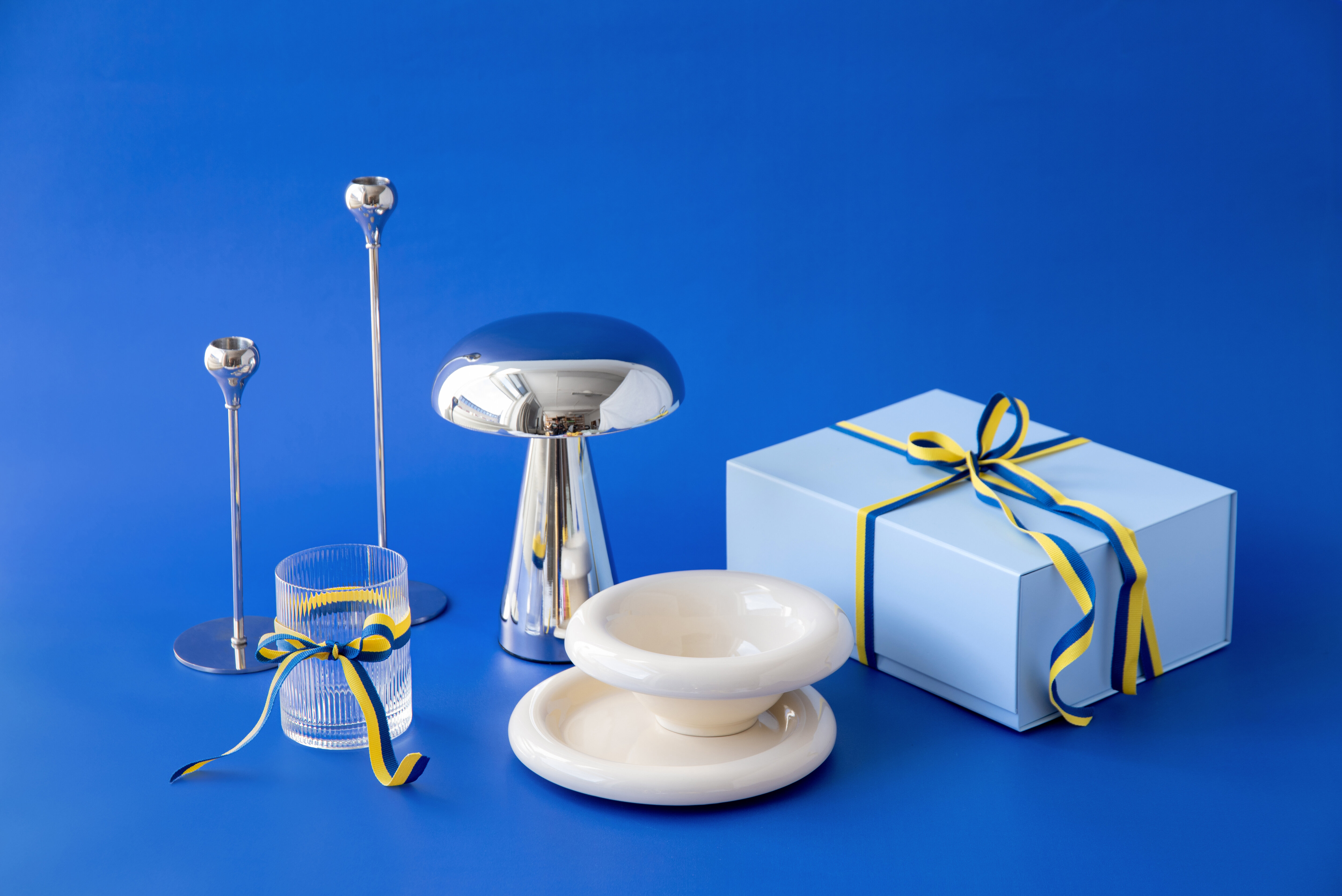 Gift box and cake on a blue background with decorative celebration details.