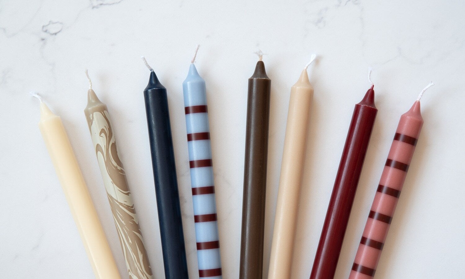 Coloured taper candles standing upright.