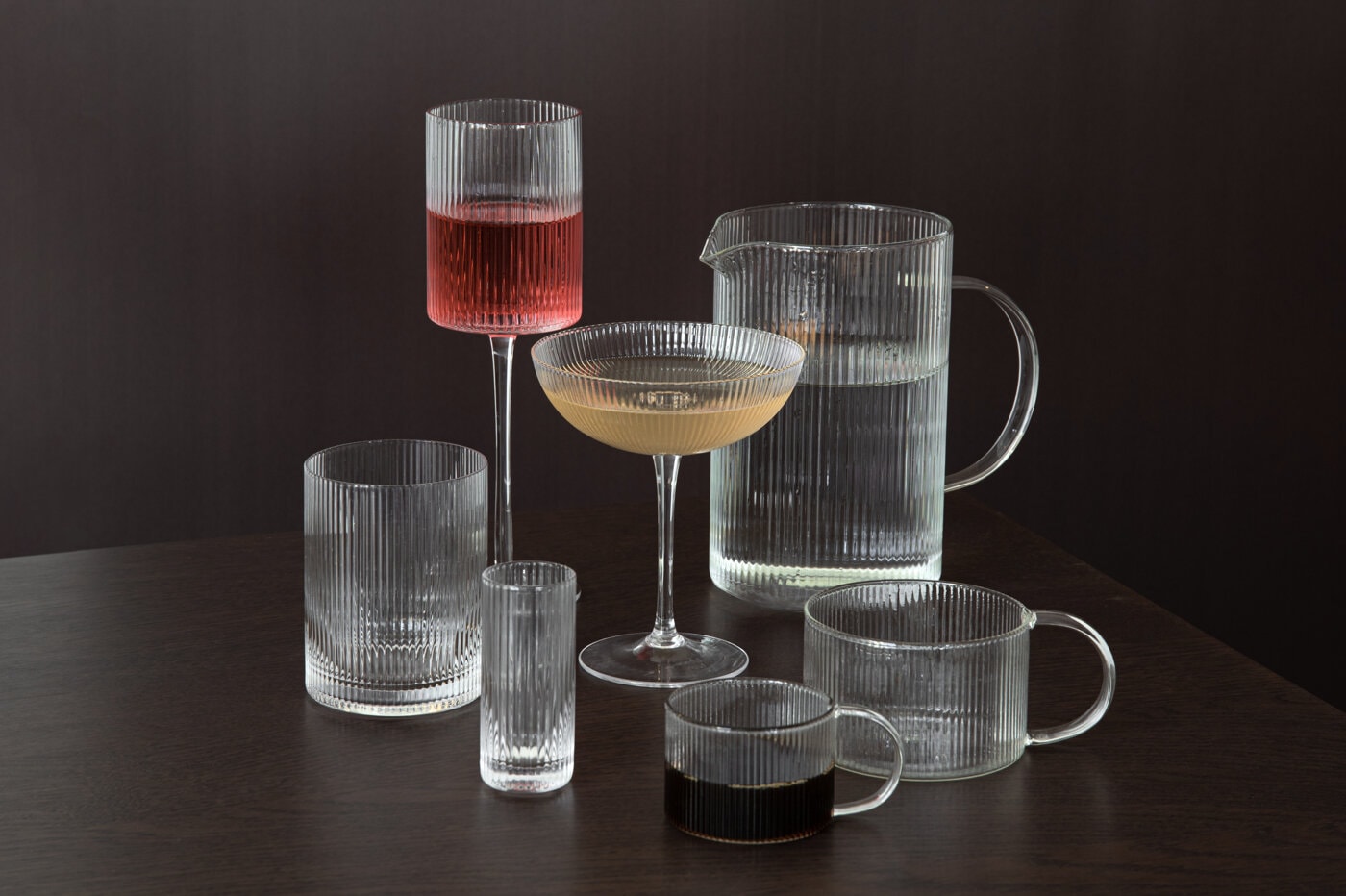 Ribbed glasses against dark brown background.